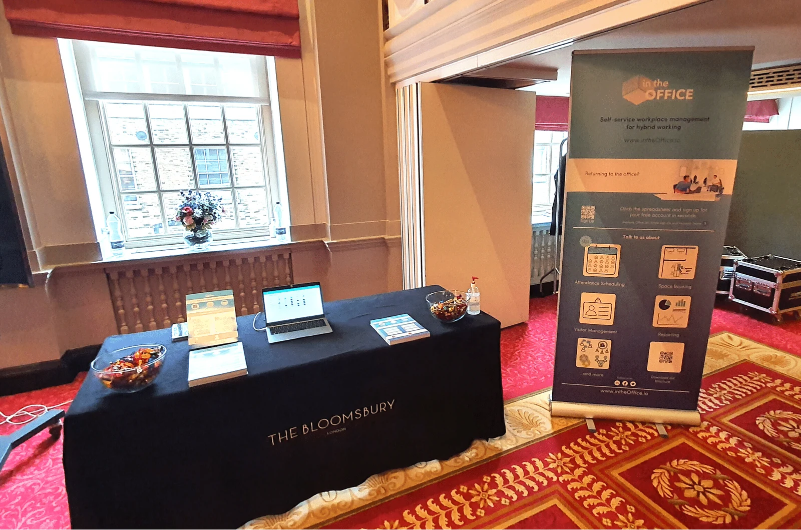 The intheOffice stand at the Office Management Show: a laptop and leaflets on a table beside a roll-up banner